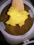 锅中木勺搅拌黄色糊状食物