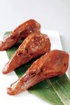 美味卤鸭头摆于绿叶上
