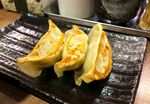 美味煎饺摆放在黑色烤盘上