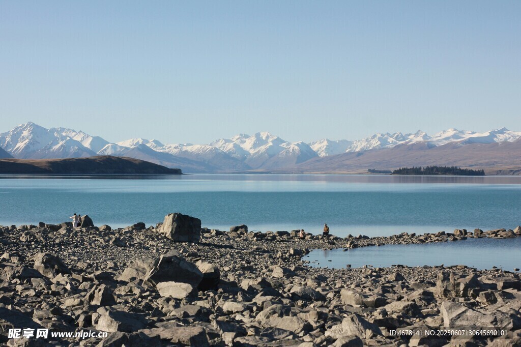 湖畔碎石与远处雪山美景