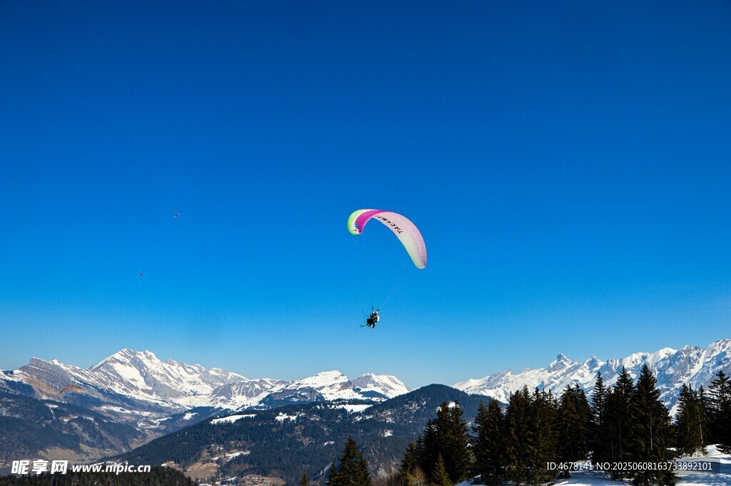 雪山上空的滑翔伞美景