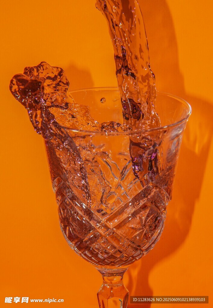 橙色背景中酒杯溅起水花