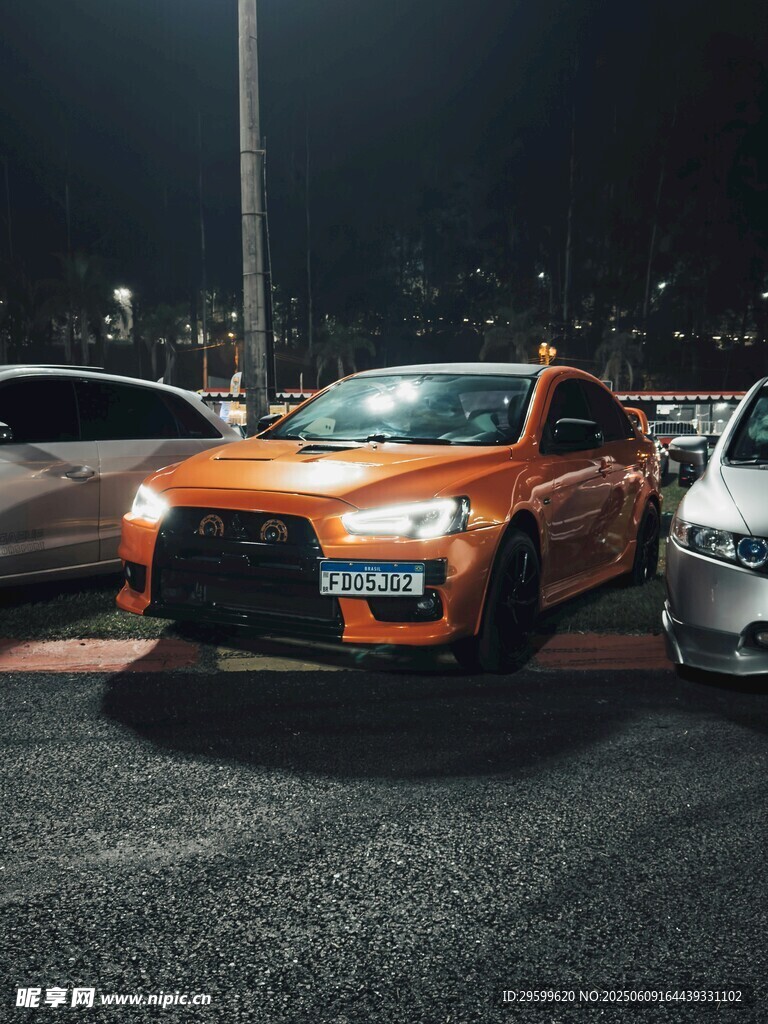 夜晚停车场中的橙色改装车