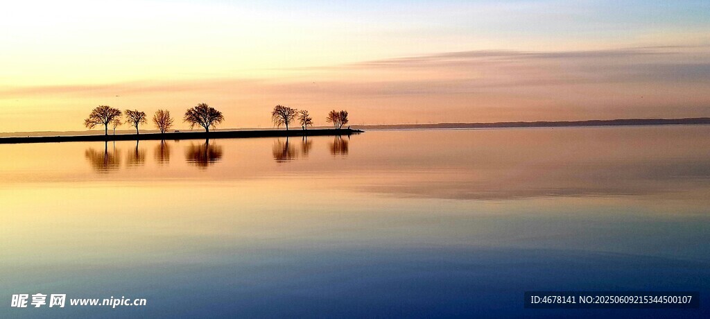 夕阳下平静湖面的船只