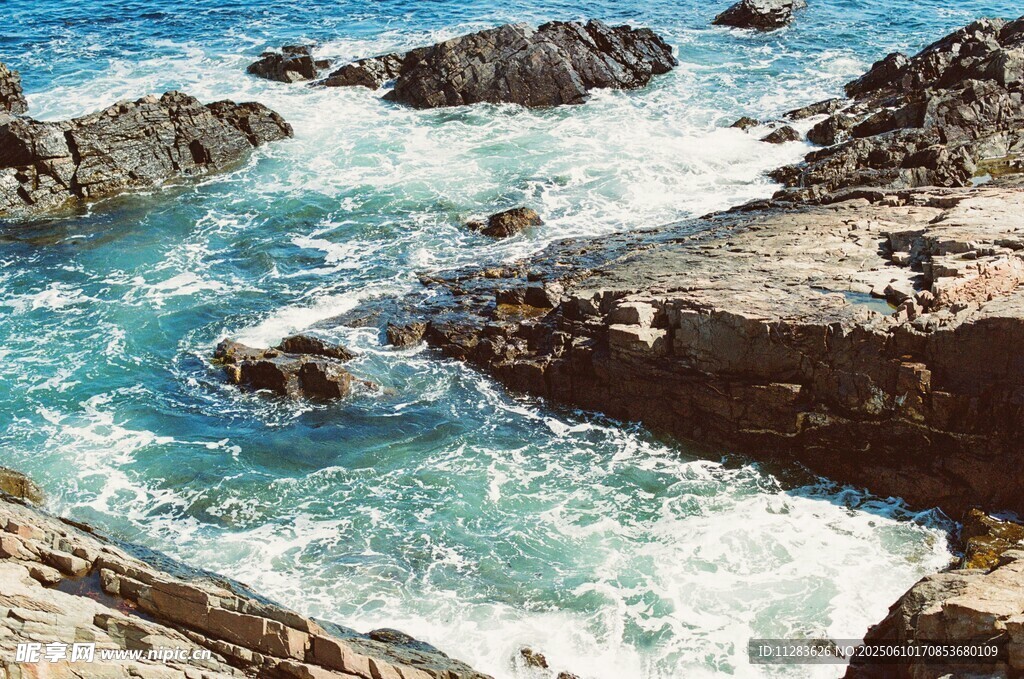 海边礁石与涌动的蓝色海浪