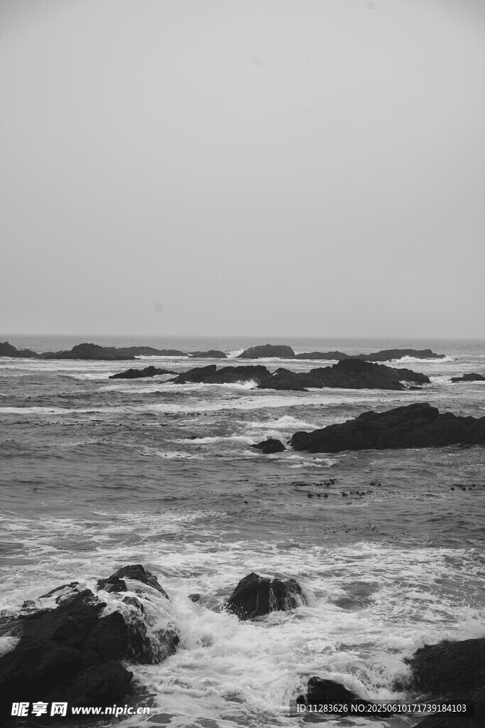 海浪拍击礁石的黑白景象