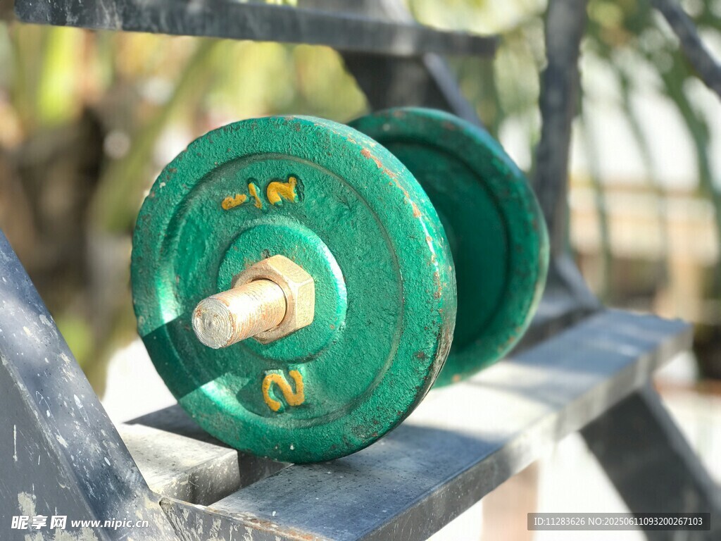 绿色哑铃置于健身器材上