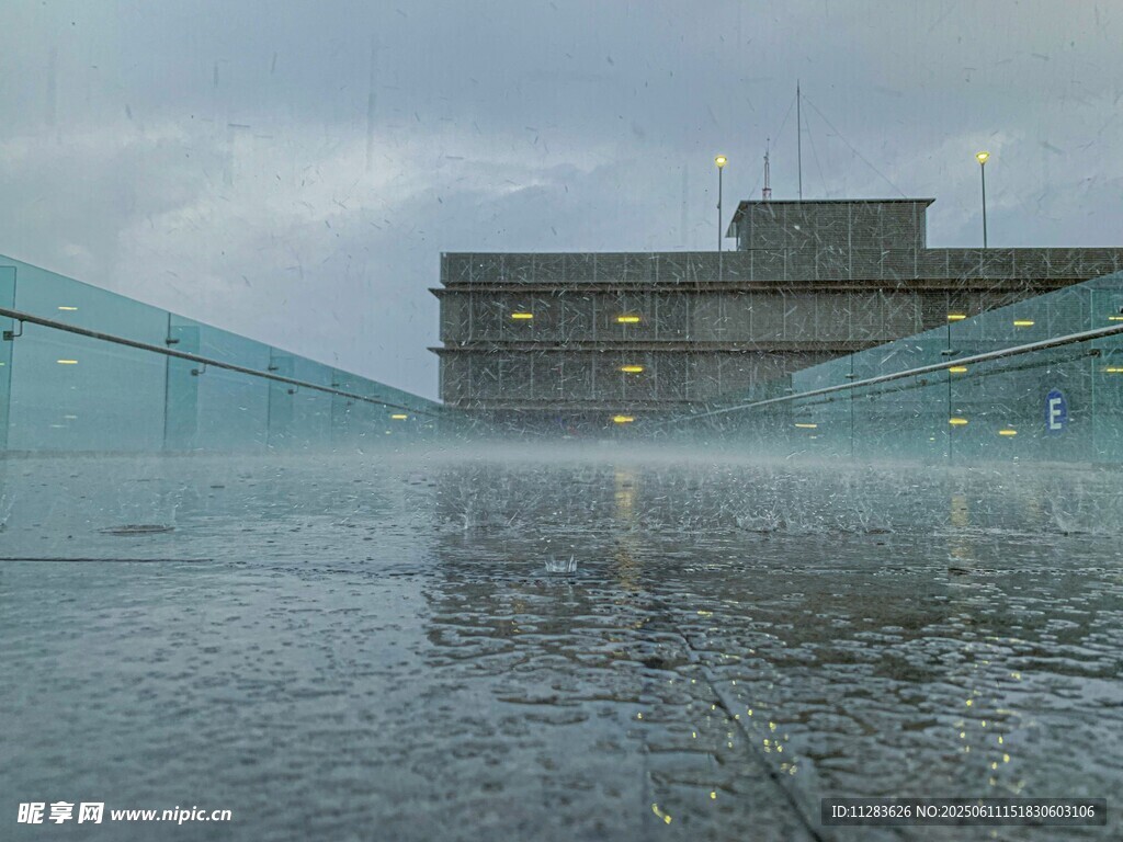 雨中玻璃建筑前的积水景象
