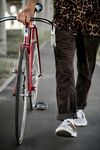 男子街头推复古红色自行车