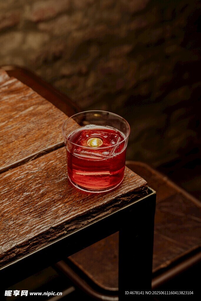 木桌上的红色烛光玻璃杯