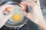 双手锅中敲鸡蛋瞬间