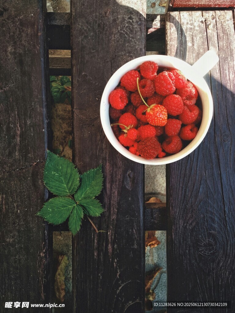 木桌上碗装新鲜红草莓