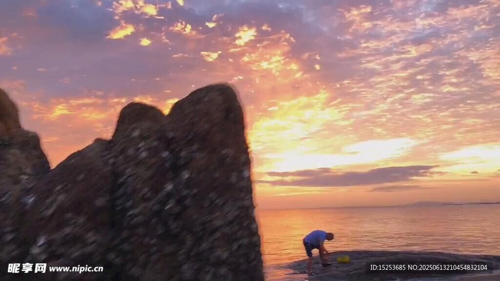 夕阳下海边的岩石与游人