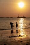 夕阳下海边的亲子时光