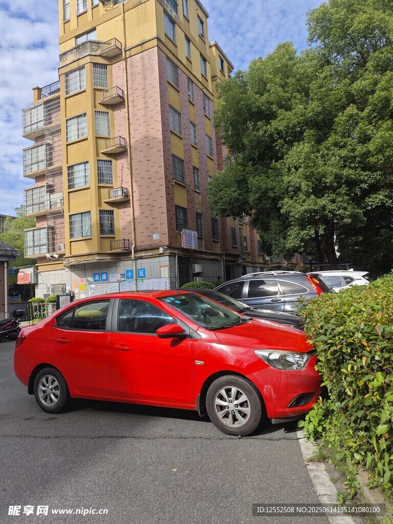 红色轿车停于居民楼旁