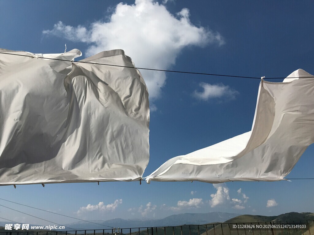 晾晒的白布在蓝天背景下