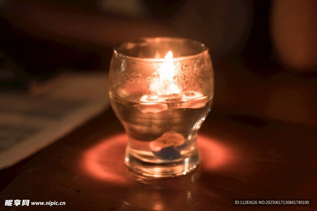 烛光映照下的透明玻璃杯