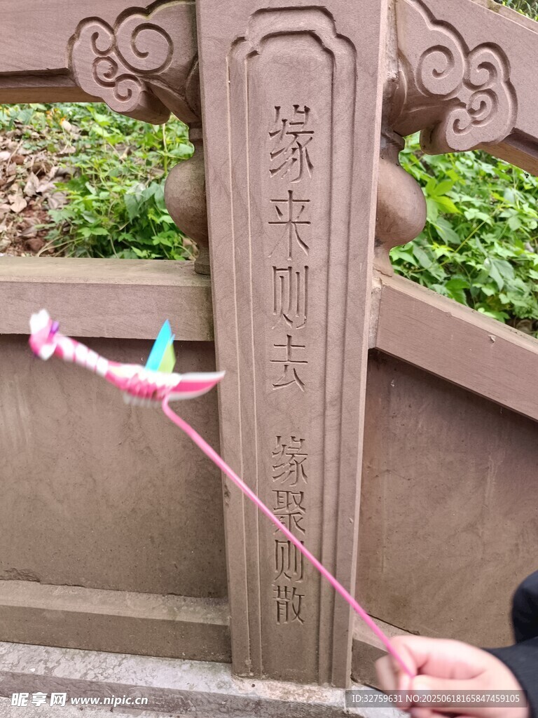 手持风车于古老石柱旁