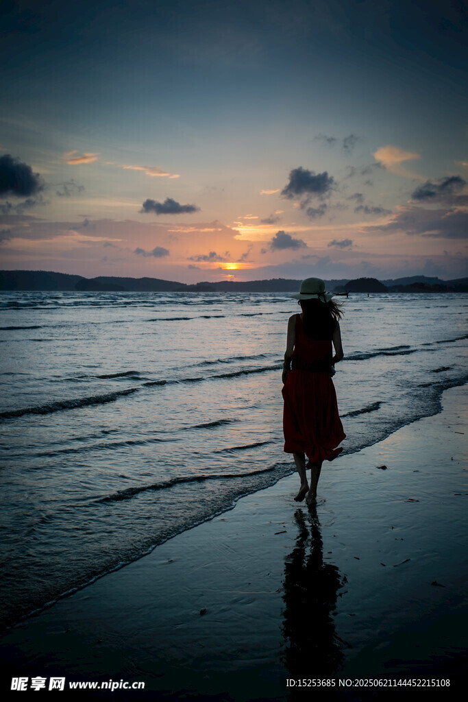 夕阳下海边独自行走的女子