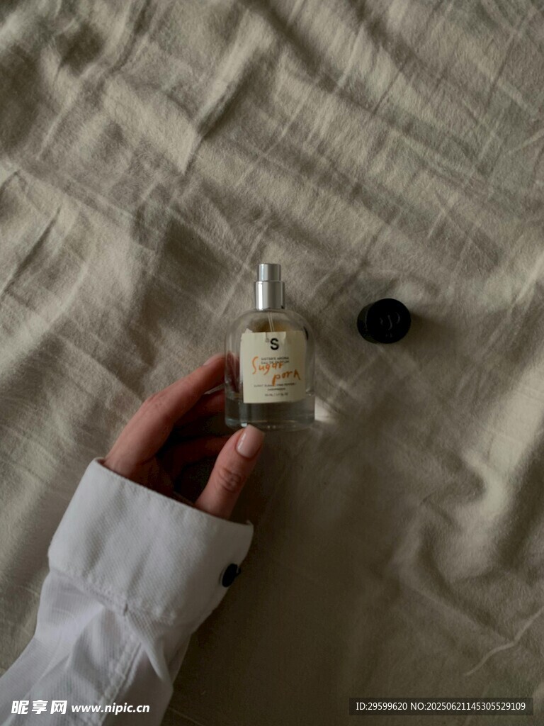 手捧香水瓶于布面之上