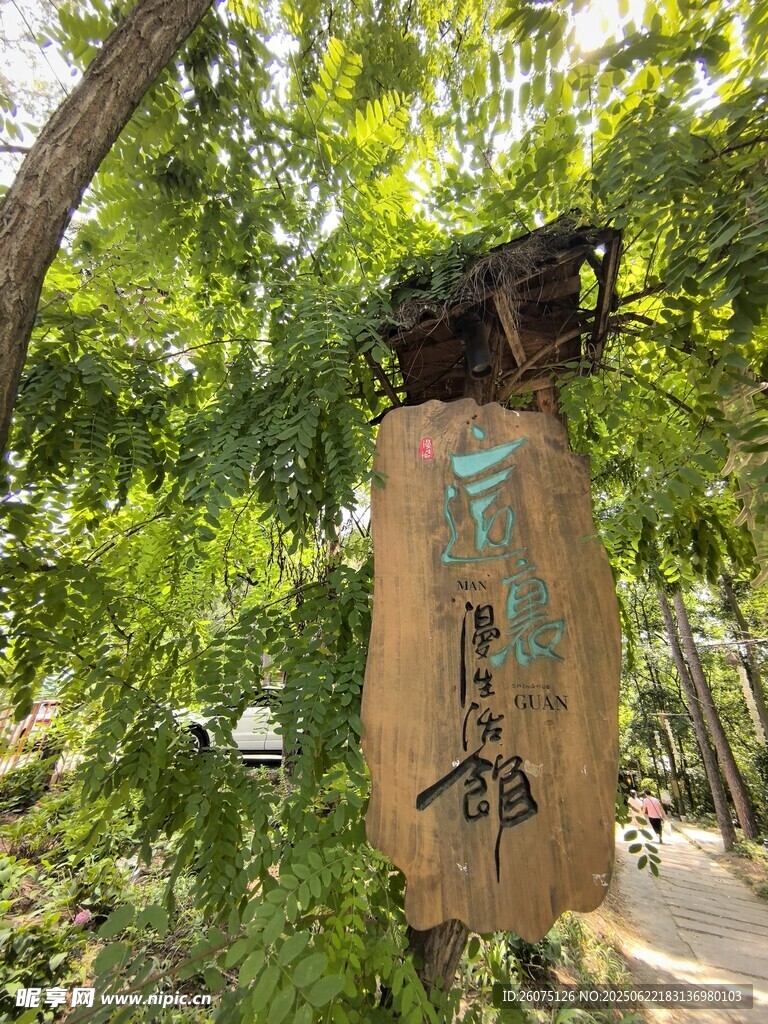 古朴中式路标隐于绿树间