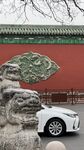 中式红墙前的白色轿车