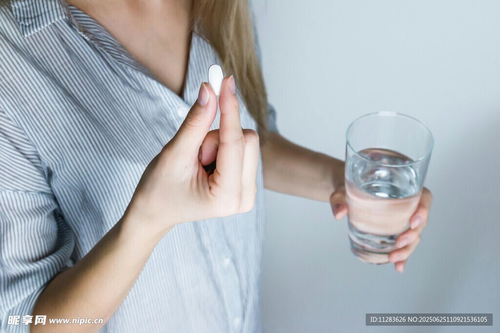女性手持药片与水杯