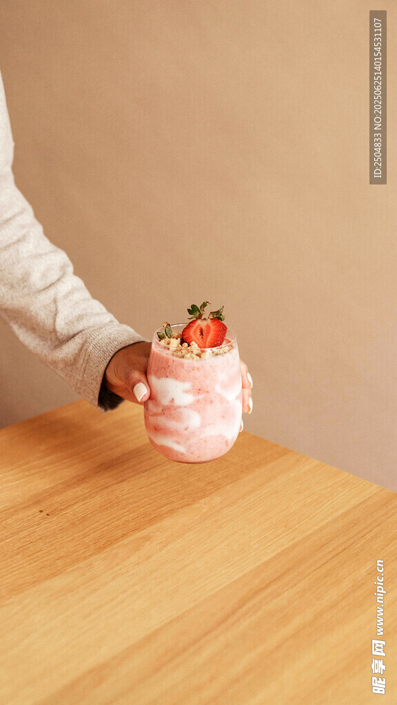 手捧草莓蛋糕于木桌前