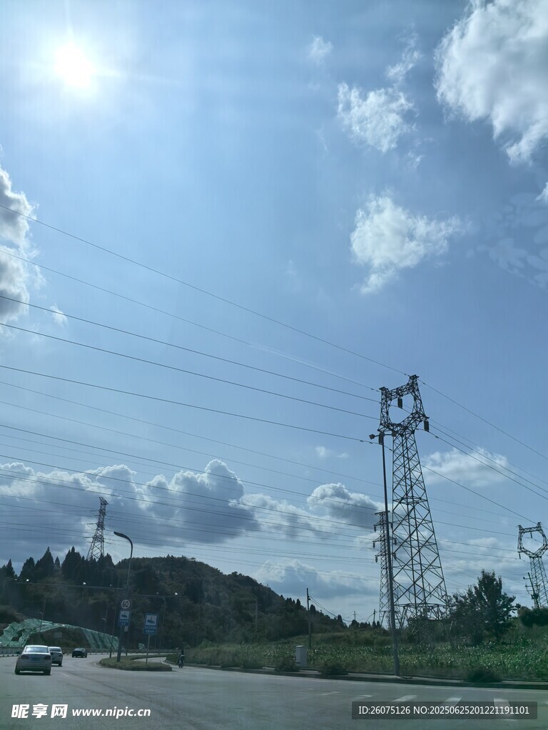 公路边的输电塔与蓝天