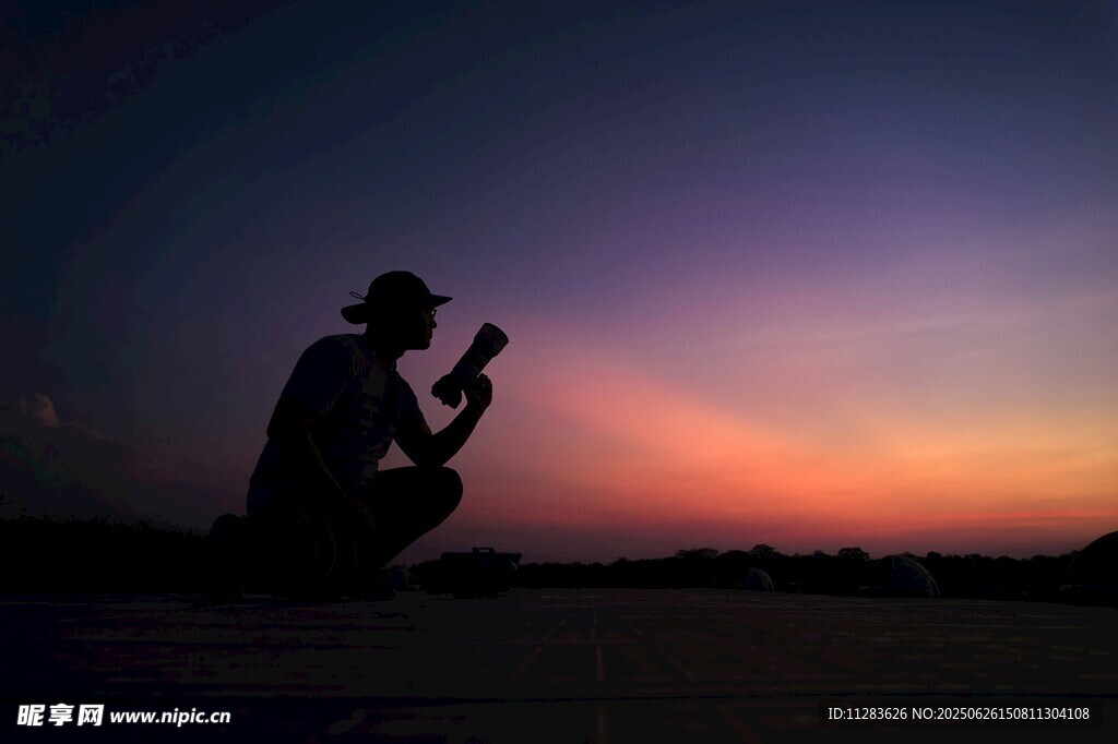 夕阳下摄影师的专注身影