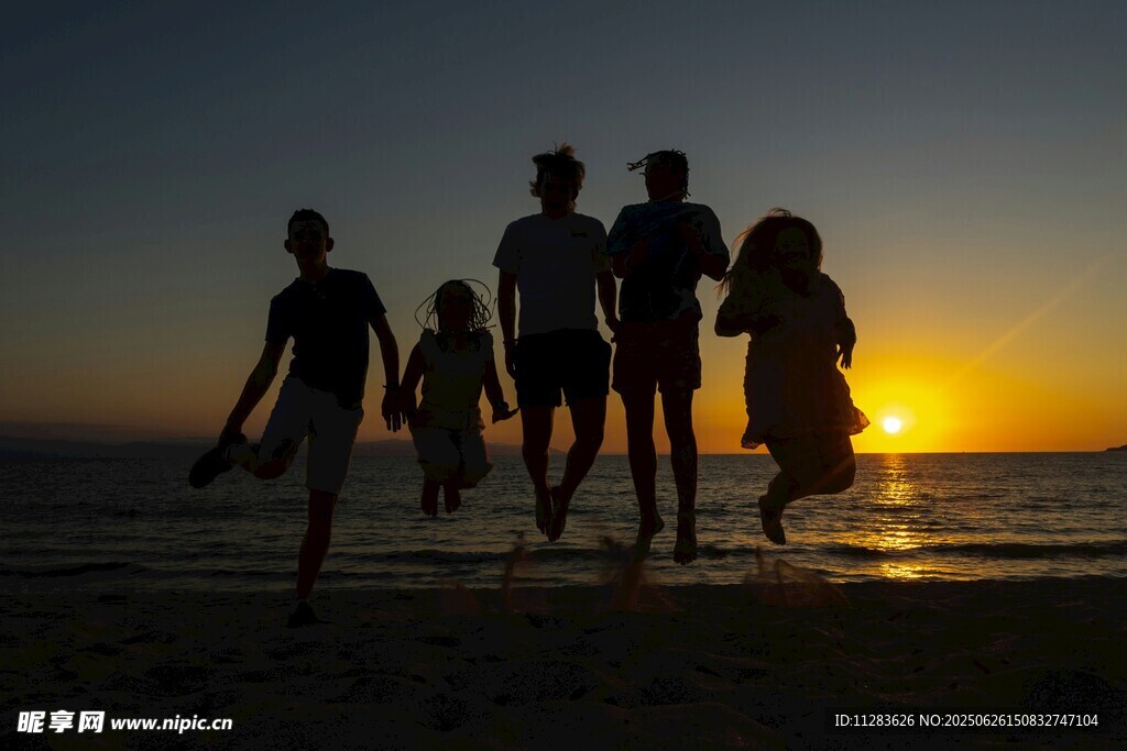 夕阳下海边漫步的人群
