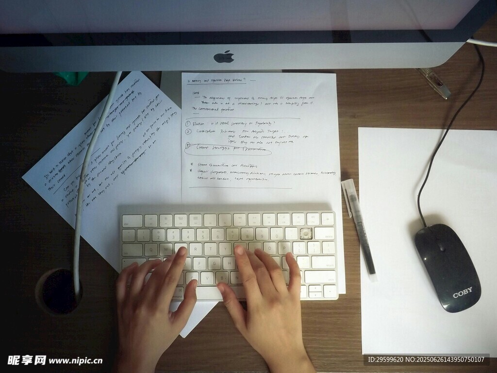 办公桌上双手操作键盘场景