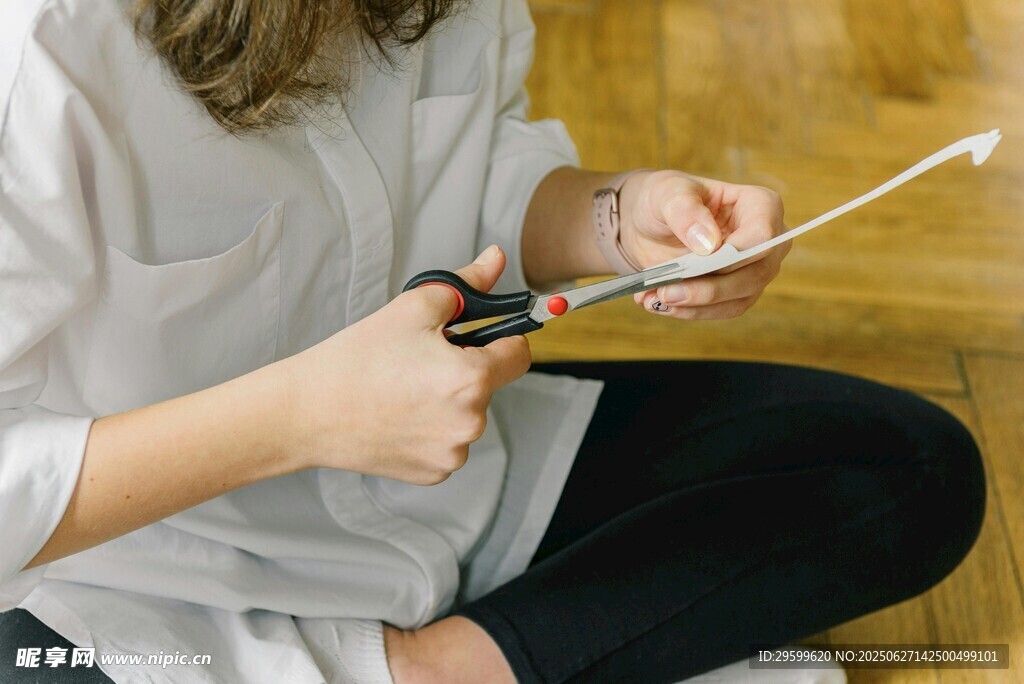 女子手持剪刀专注做手工