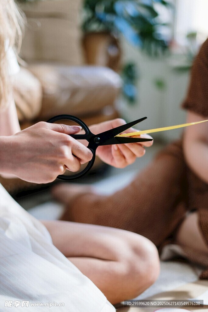 女性手持剪刀与黄色物件