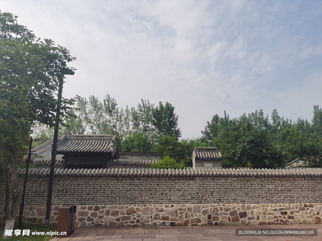 古朴围墙旁的绿树与建筑