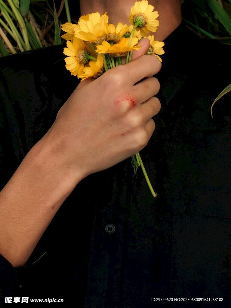 手持黄色小花的手部特写