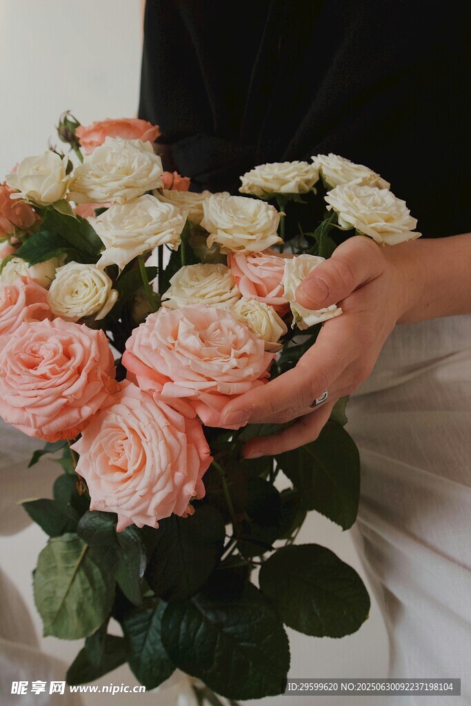 手捧柔美粉白玫瑰花束