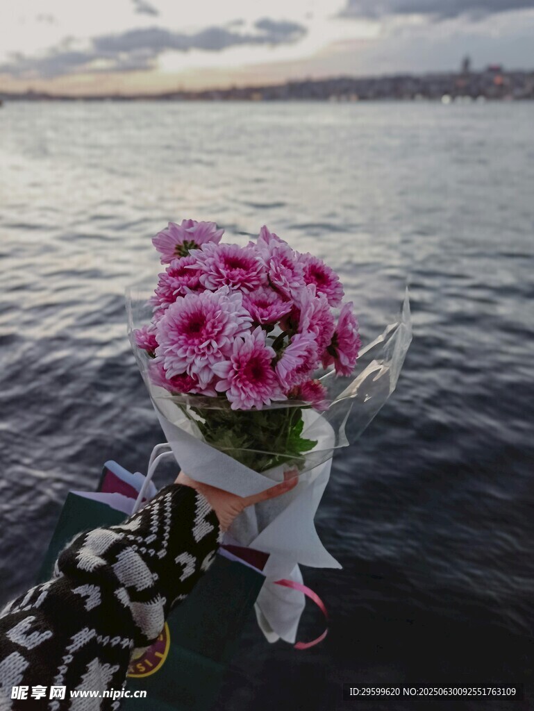 海边手持的粉色鲜花束