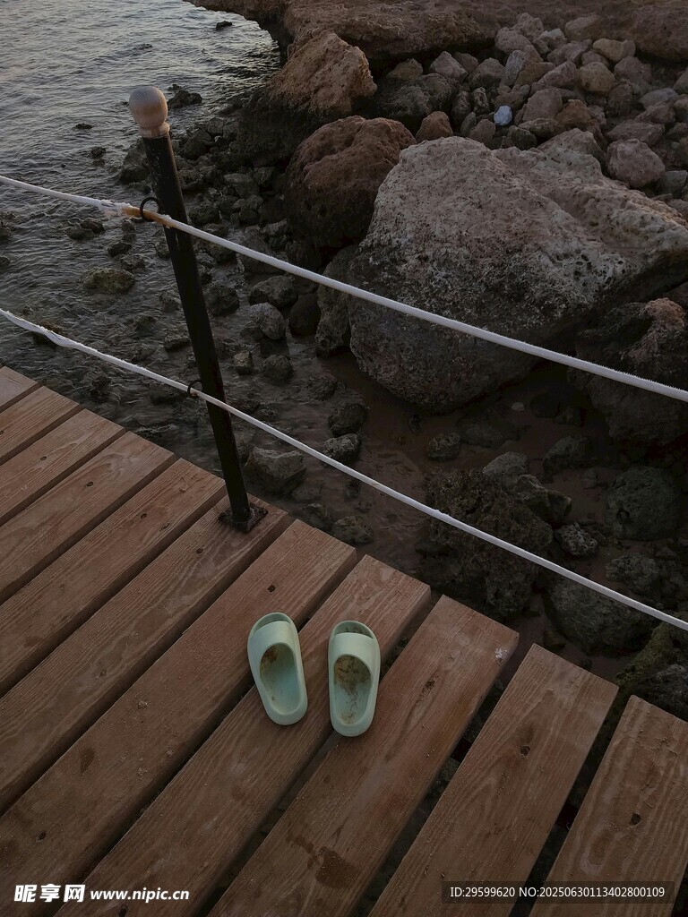 木栈道上的一双浅绿色拖鞋