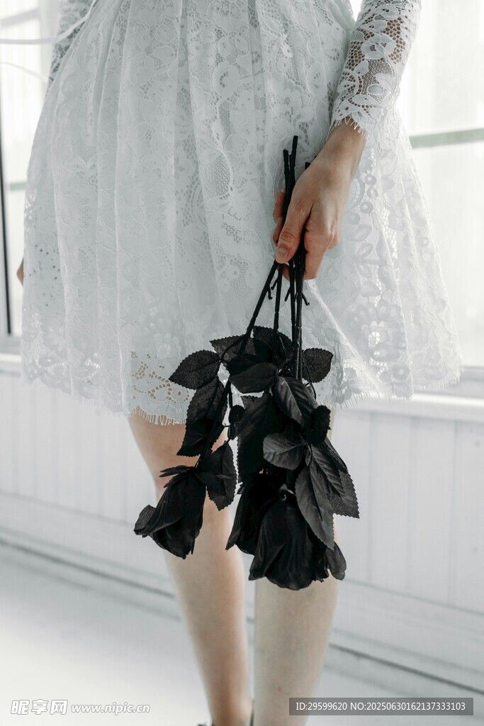 女子手持黑色花朵手提包