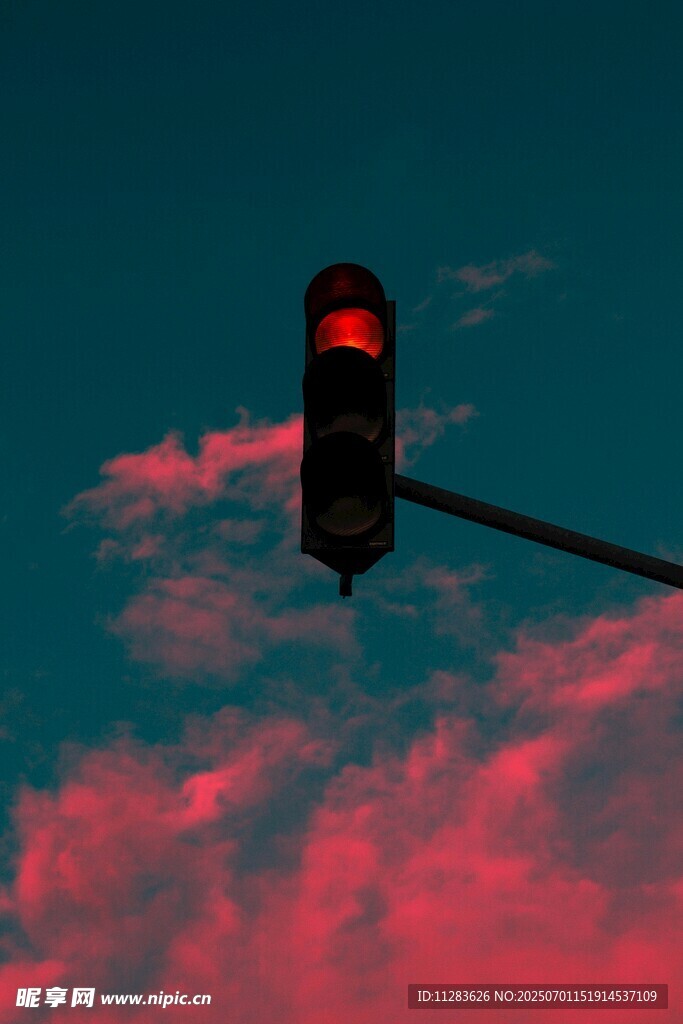 晚霞中的红色交通信号灯