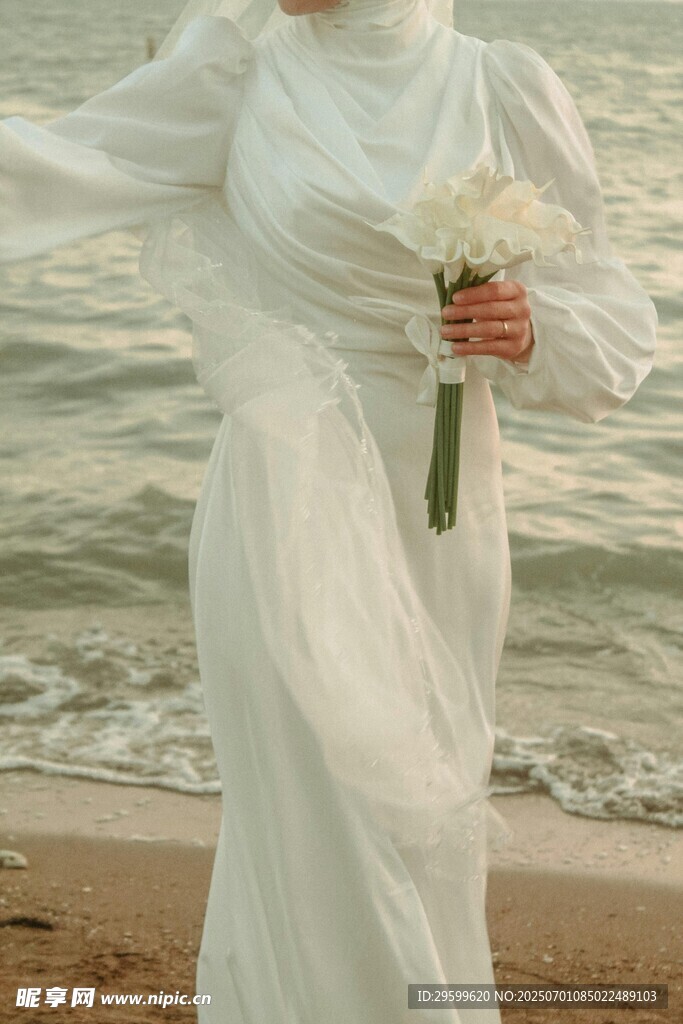 海边白衣女子手持花束