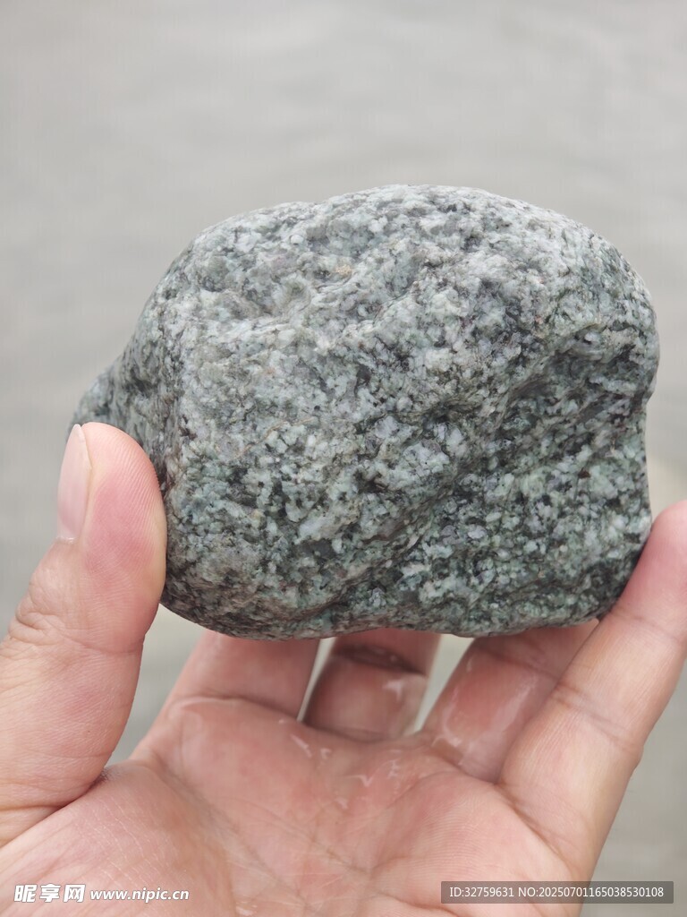 手持灰黑色粗糙石头
