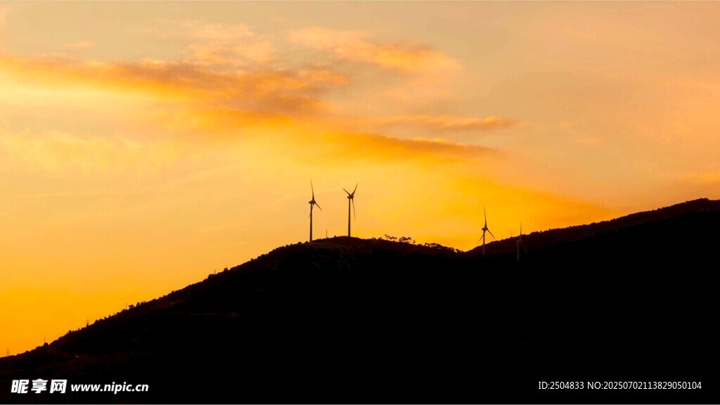 夕阳下的山丘与风力发电机