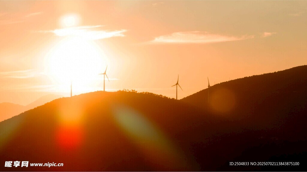 夕阳下的山丘与风力发电机