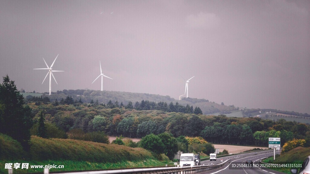 雨中公路旁的风力发电机组