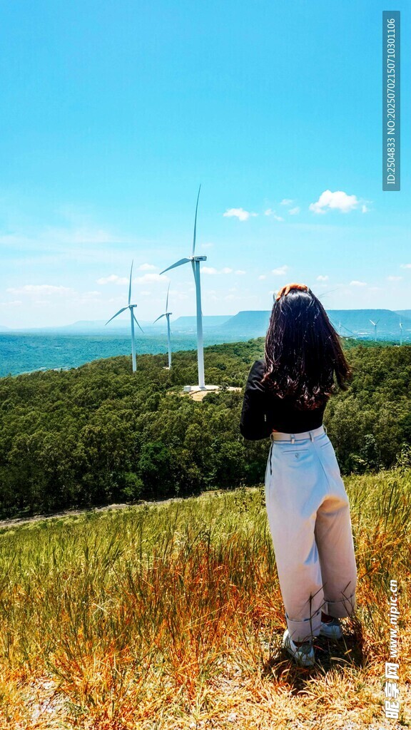女子赏景于风车草原之上