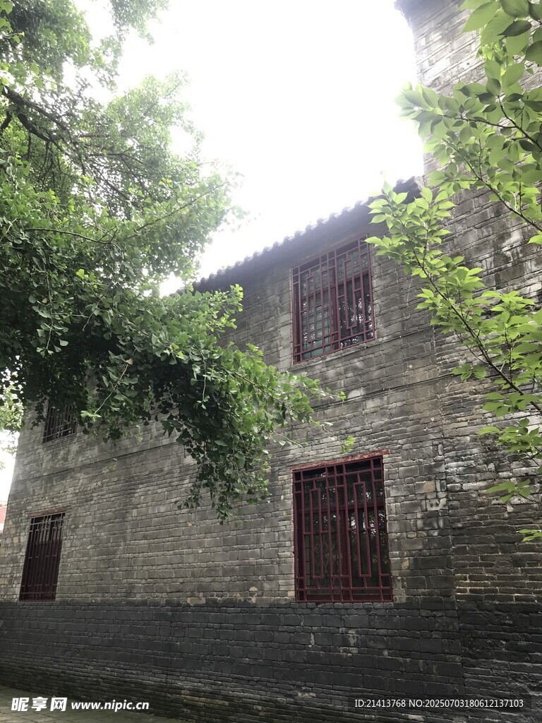 古朴石砌房屋与繁茂绿树