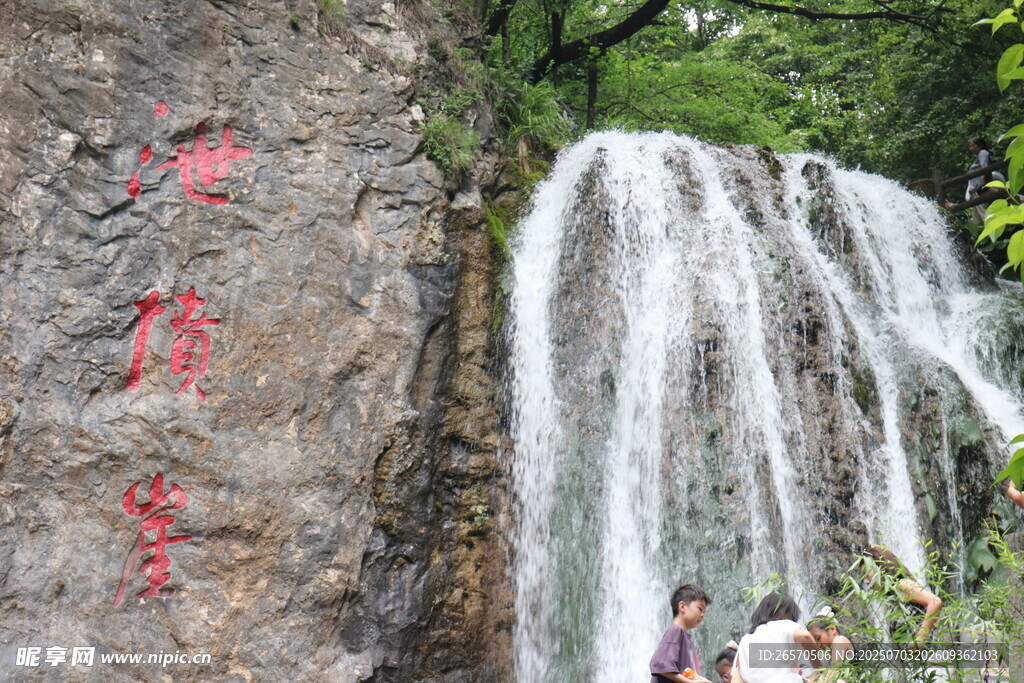 山间瀑布旁的游人赏景