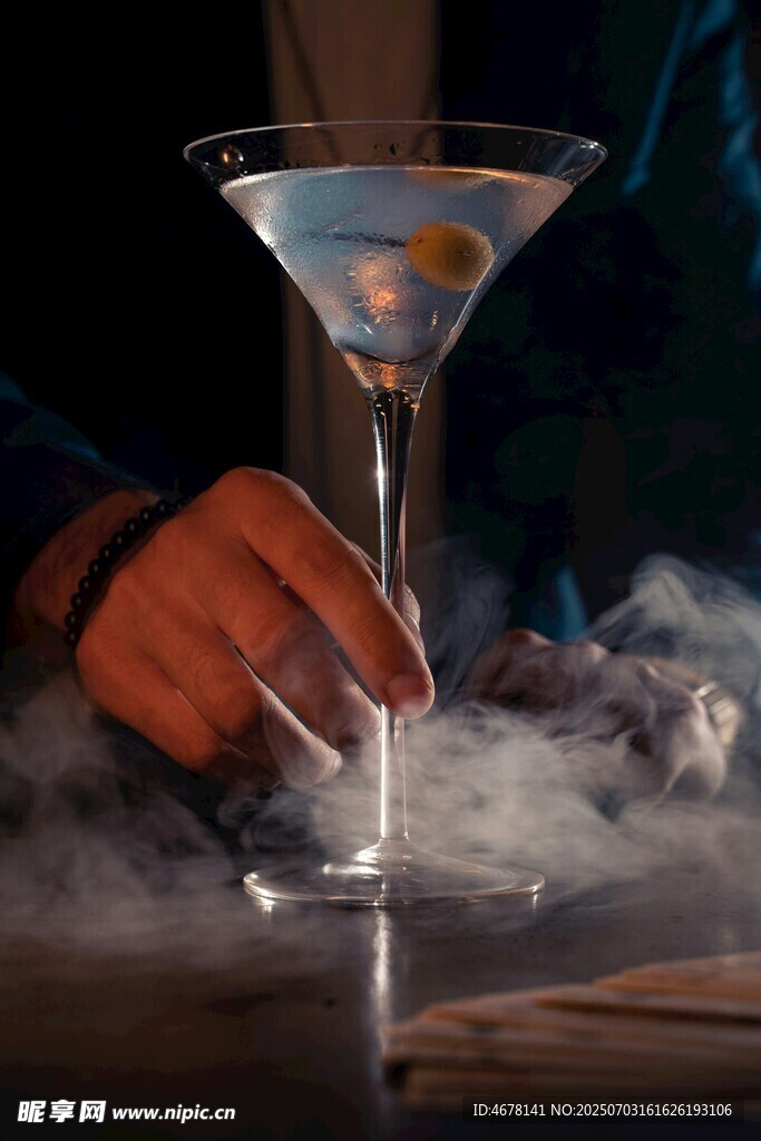 手触烟雾中的马天尼酒杯